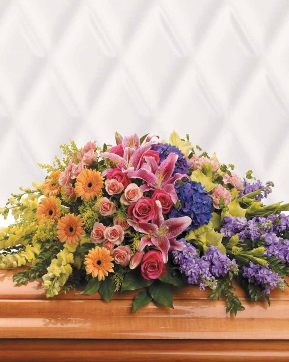 Garden of Sweet Memories Casket Spray Half Caket Spray-Standard A loved one may have passed, but the memory of many happy times together will last forever. This radiant, multicolored spray is a tribute to that spirit. The elegant arrangement includes purple hydrangea, hot pink roses, peach spray roses, pink stargazer lilies, peach miniature gerberas, green gladioli, pink carnations, yellow snapdragons, lavender stock and solidago, accented with assorted greenery. Approximately 42