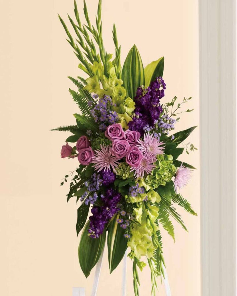 Endless Sky Standing Spray Standard Soft lavender flowers - roses, fuji chrysanthemums and asters - blend with rich purple stock, yellow gladioli and majestic green hydrangea in this bold floral celebration of life. This stunning standing spray incorporates lush tropical greenery.
DELIVERY: Every order is hand-delivered direct to the recipient. These items will be delivered by us locally, or a qualified retail local florist.