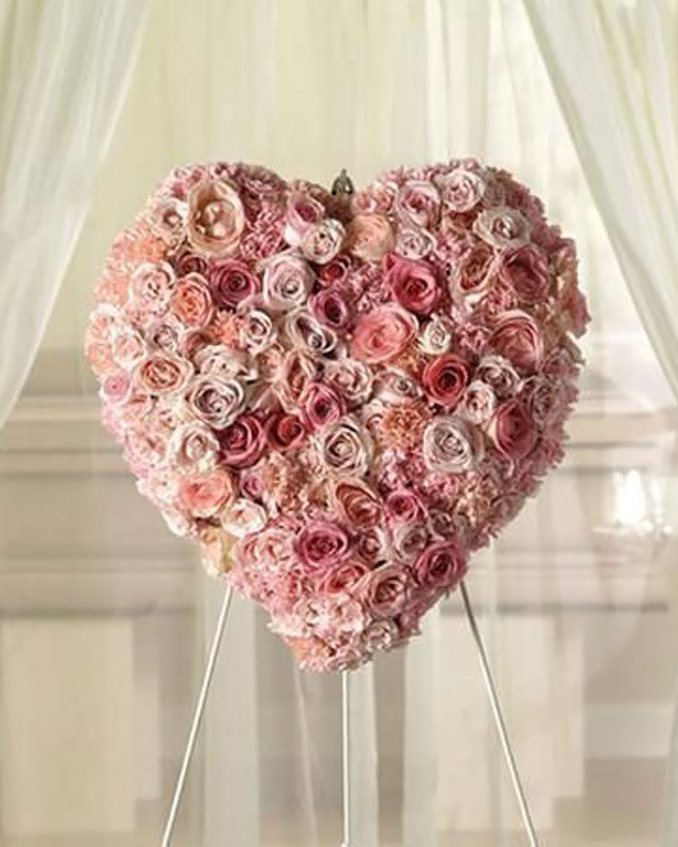 Stunning Memorial Heart Standard (18 Inch) Express your love with this beautiful heart standing spray, featuring varied shades of pink roses tightly clustered together.
DELIVERY: Every order is hand-delivered direct to the recipient. These items will be delivered by us locally, or a qualified retail local florist.