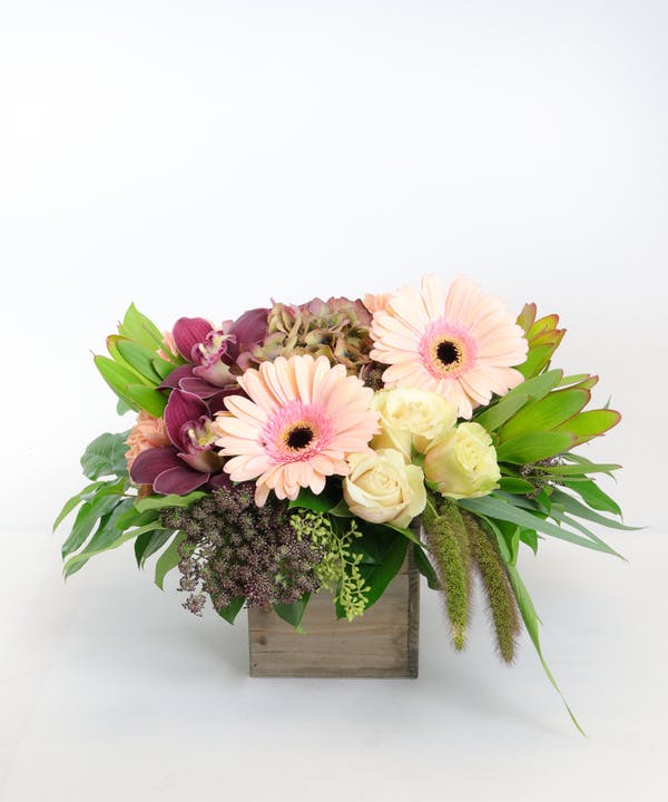 Burgundy Blush Deluxe 
Burgundy Blush
The expert design team at Allen's Flower Market in Long Beach out did themselves with this fabulous fresh flower design. It features burgundy cymbidium orchids, antique hydrangea, blush gerbera daisies, ivory roses and other premium florals are combined to create a stunning floral palette, all presented in a chic wooden box.

DELIVERY: Every order is hand-delivered direct to the recipient. These items will be delivered by us locally, or a qualified, retail, local florist..
