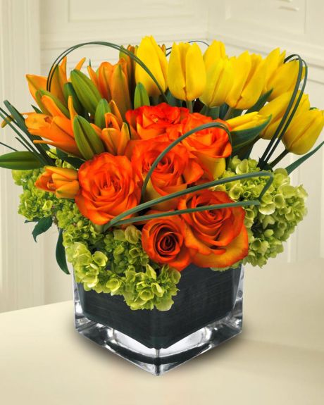 Tip Top-Tulips, Roses, Tiger Lillies, Mini Green Hydrangea, and Bear Grass arranged in a Ti Leaf Lined Cube.-Fall Arrangement