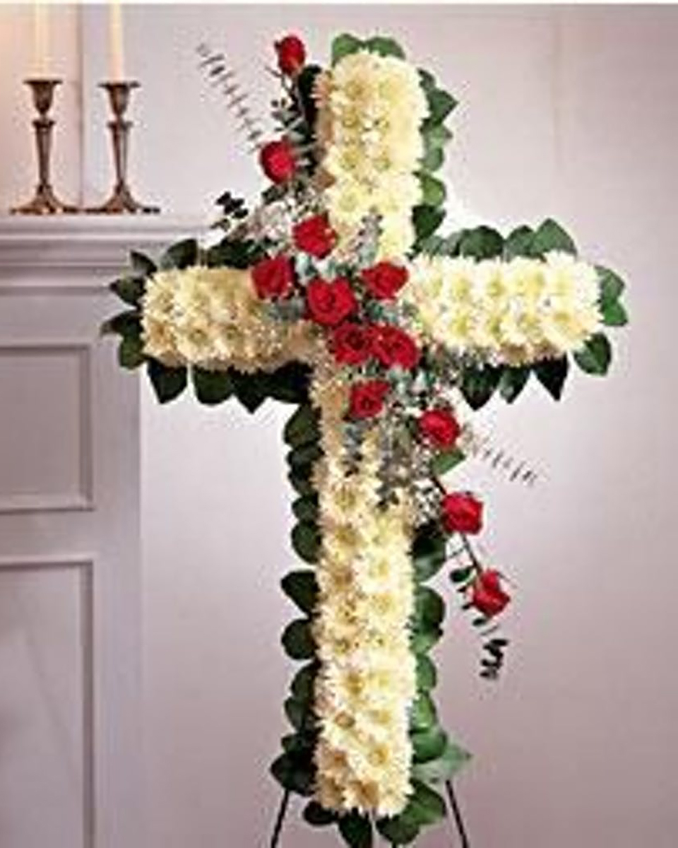 La Cruz Standard (24 Inch) This standing spray arrangement, in the shape of a cross, is created from fresh roses, cushion mums, greenery and floral accents for a meaningful tribute. This arrangement is traditionally sent directly to the funeral home by a family member or friend and is displayed on a stand. Our florists use only the freshest flowers available so varieties and colors may vary.  
DELIVERY: Every order is hand-delivered direct to the recipient. These items will be delivered by us locally, or a qualified retail local florist.