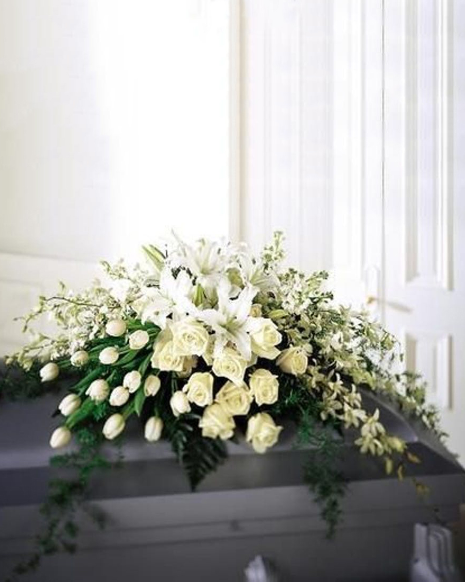 A Majestic Cover Half Casket Spray-Standard This beautiful all white casket cover brings a simple comfort to family and friends.
DELIVERY: Every order is hand-delivered direct to the recipient. These items will be delivered by us locally, or a qualified retail local florist.