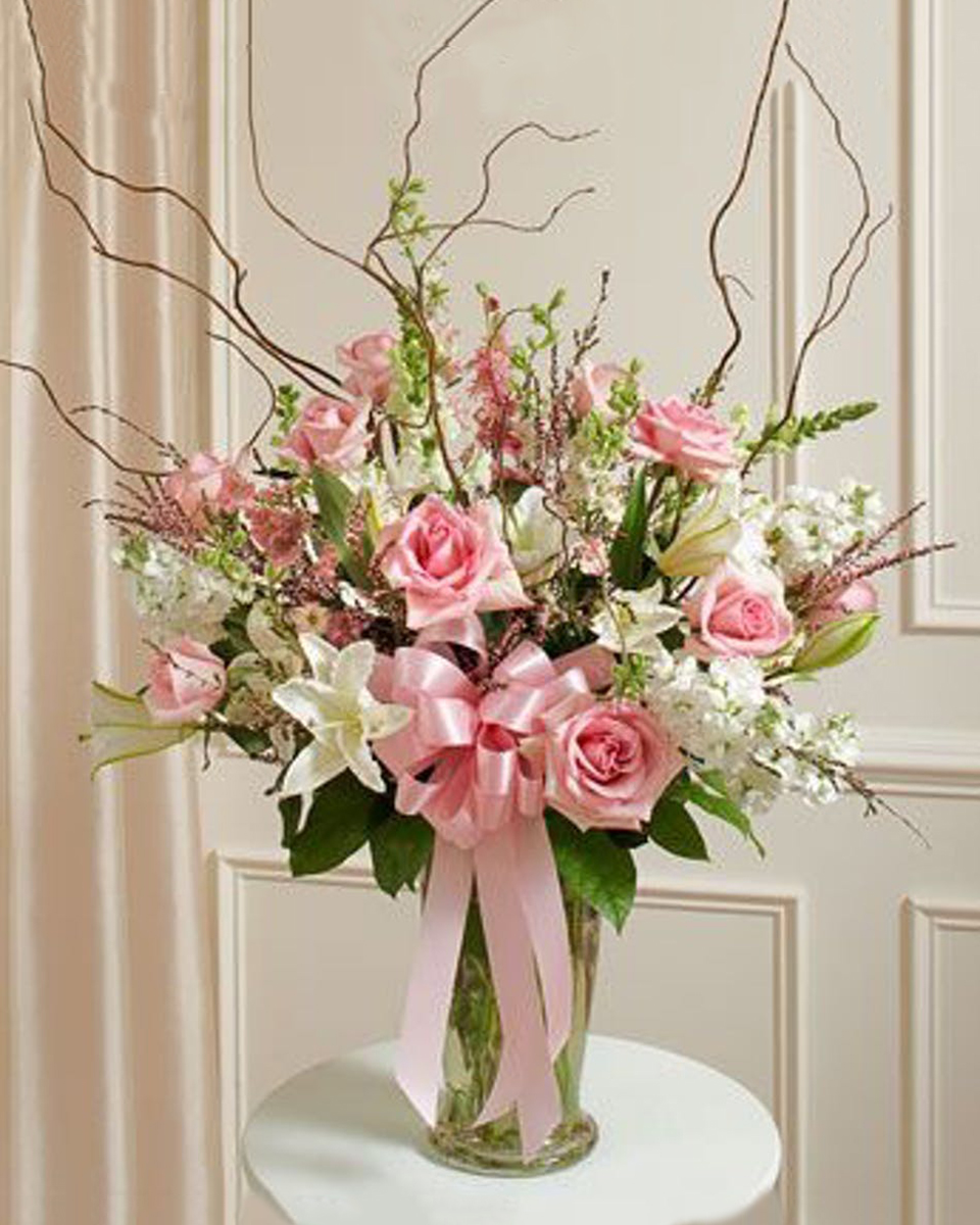 Sympathy Garden Vase Standard An elegant of expression of condolence featuring beautiful roses, lilies and complementary flowers, accented with curly willow. *Vase meaures 11