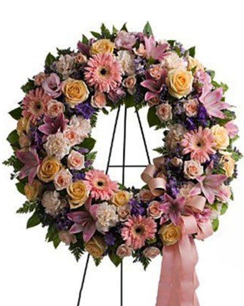 Graceful Wreath Standard (18 Inch) A graceful, feminine wreath created with a range of beautiful blossoms in peach, pink, crème and lavender is a lovely depiction of your warm feelings and devotion. Delivered on an easel, for display at a funeral service or wake.
DELIVERY: Every order is hand-delivered direct to the recipient. These items will be delivered by us locally, or a qualified retail local florist.
