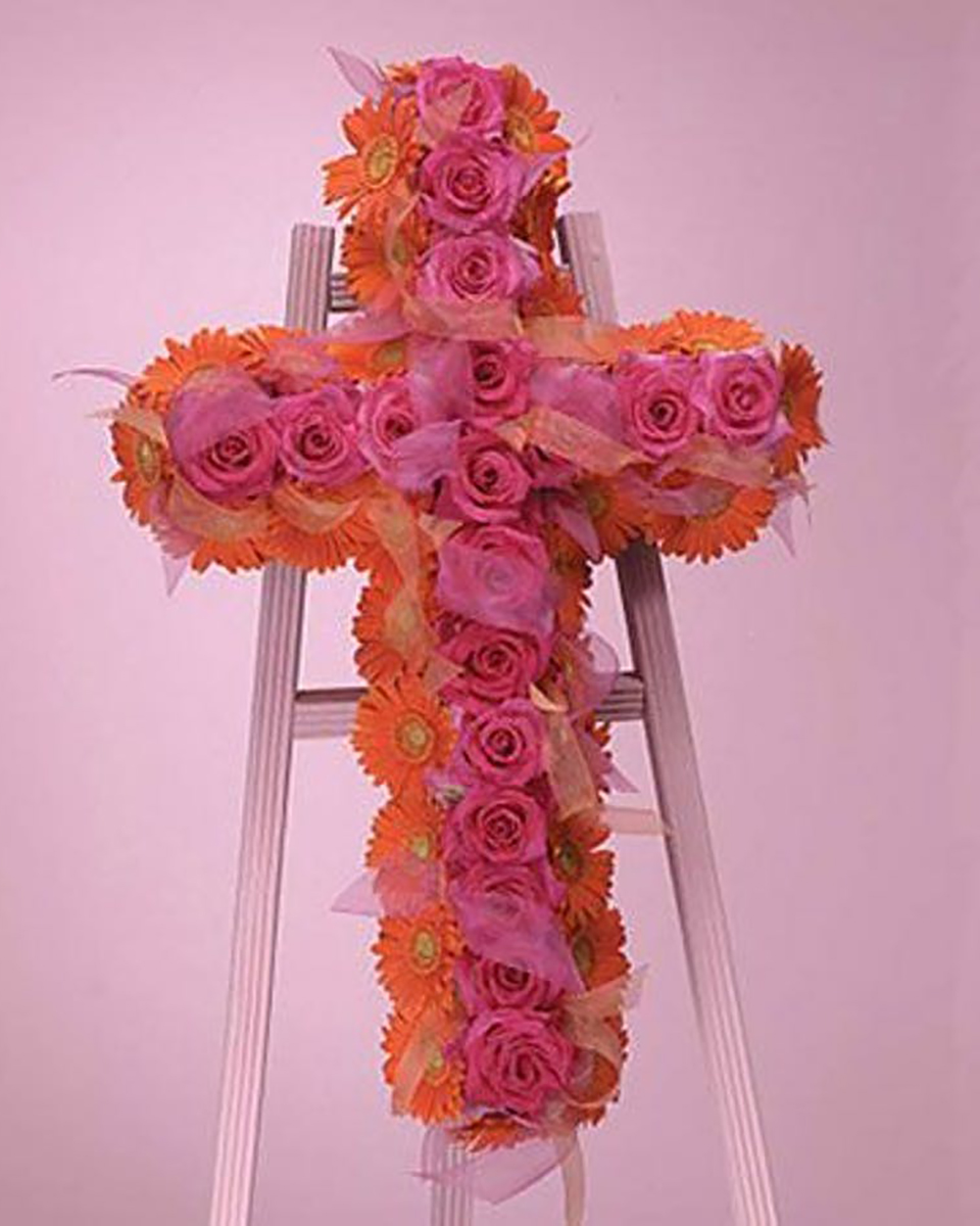 Gerbera and Rose Cross Standard (24 Inch) A stunning and dramatic design of favorite gerbera daisies framing pink garden roses and accented with sheer ribbons. Delivered on a deluxe easle.
DELIVERY: Every order is hand-delivered direct to the recipient. These items will be delivered by us locally, or a qualified retail local florist.