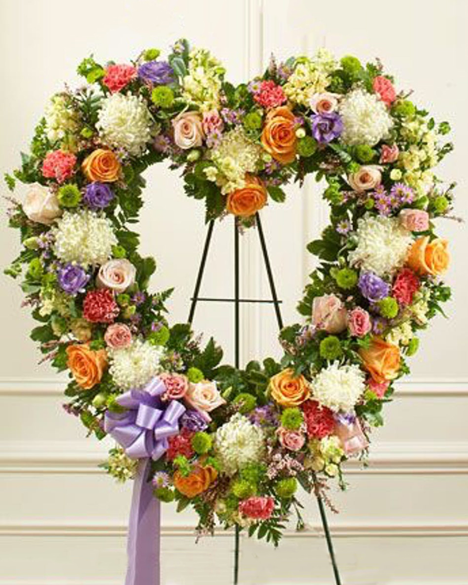 Open Heart Wreath in Spring Colors Standard (18 Inch) Elegant heart shaped sympathy wreath. The mix of multicolored pastel garden flowers used to create this wreath express your sympathy and concern. This is an ideal way to honor a loved one. 
DELIVERY: Every order is hand-delivered direct to the recipient. These items will be delivered by us locally, or a qualified retail local florist.