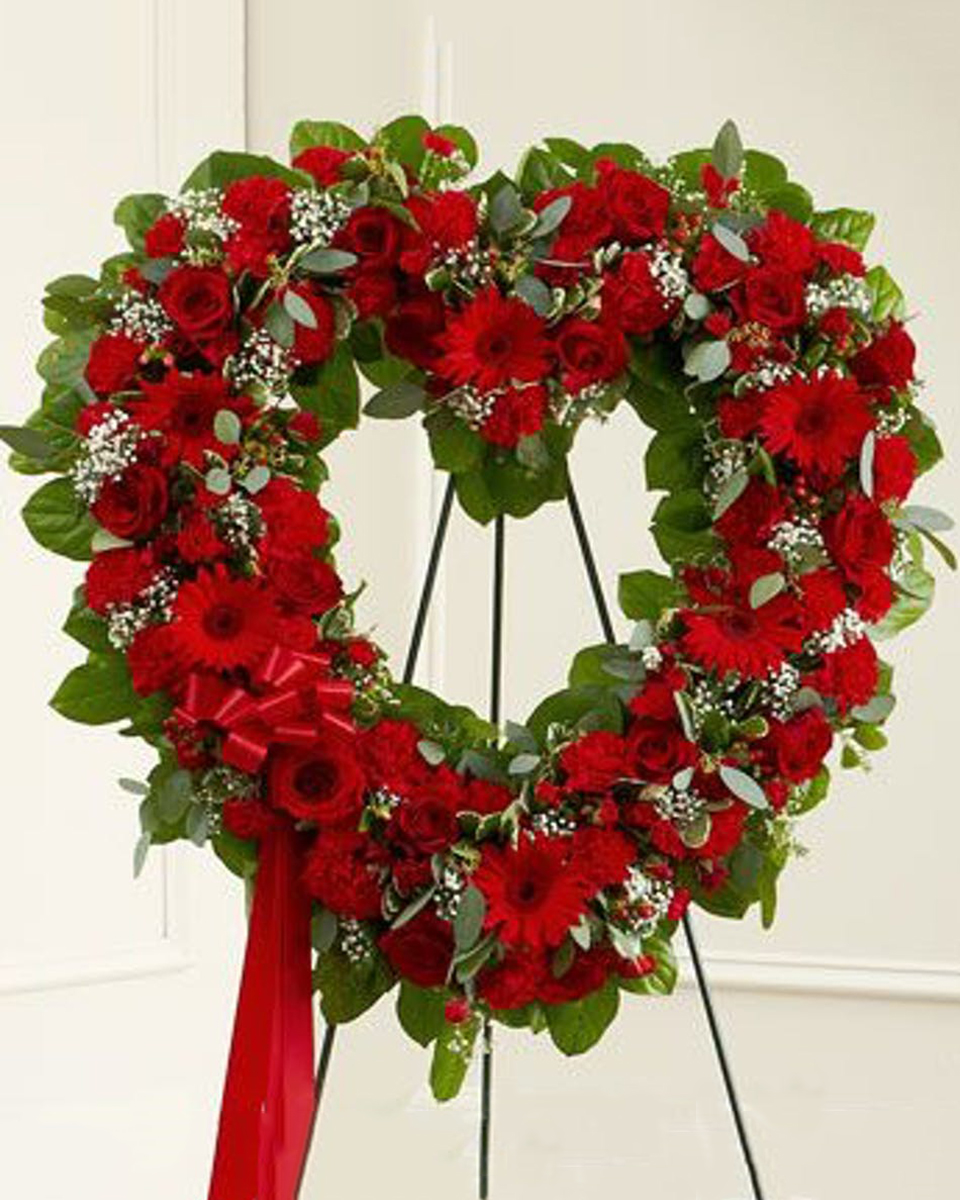 RoseHeart Wreath Standard (18 Inch) A truly stunning design, the standing open heart is created using red roses, gerbera daisise, eucalyptus and more.
DELIVERY: Every order is hand-delivered direct to the recipient. These items will be delivered by us locally, or a qualified retail local florist.
