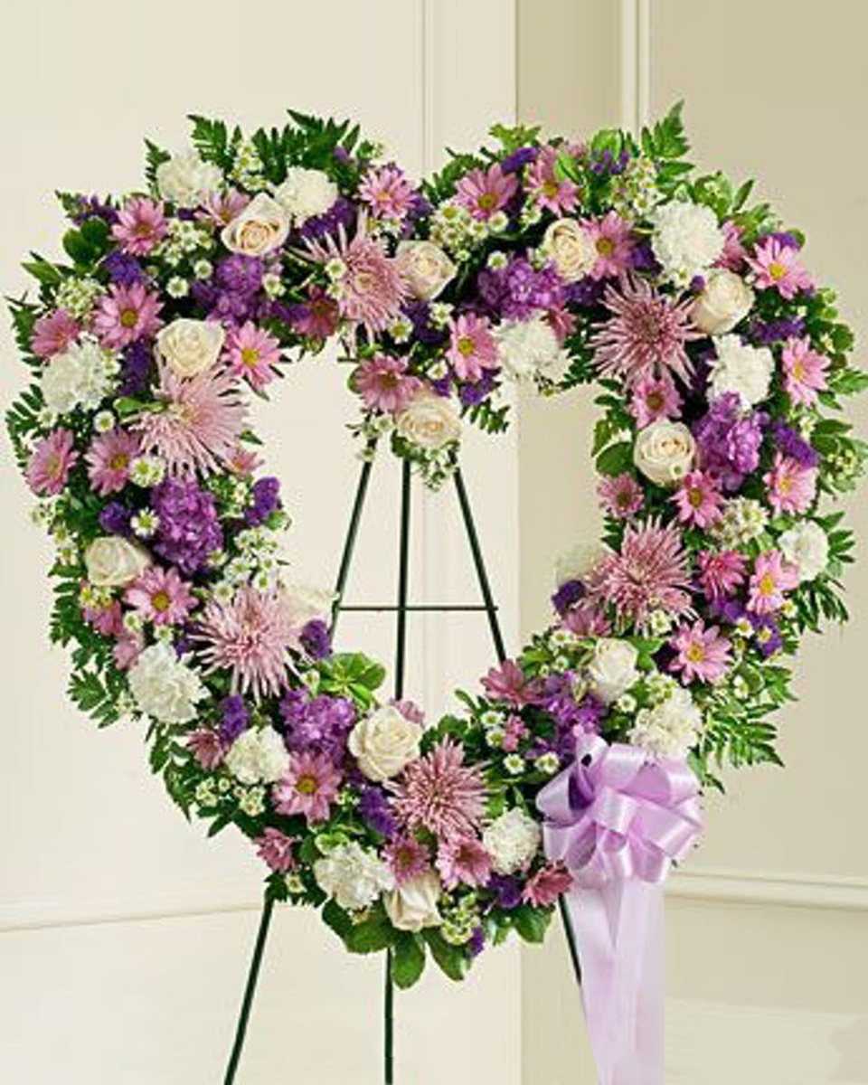 Of the Heart Standard (18 Inch) Convey your deepest condolences with this standing arrangement containing a variety of lavender and white flowers.
DELIVERY: Every order is hand-delivered direct to the recipient. These items will be delivered by us locally, or a qualified retail local florist.