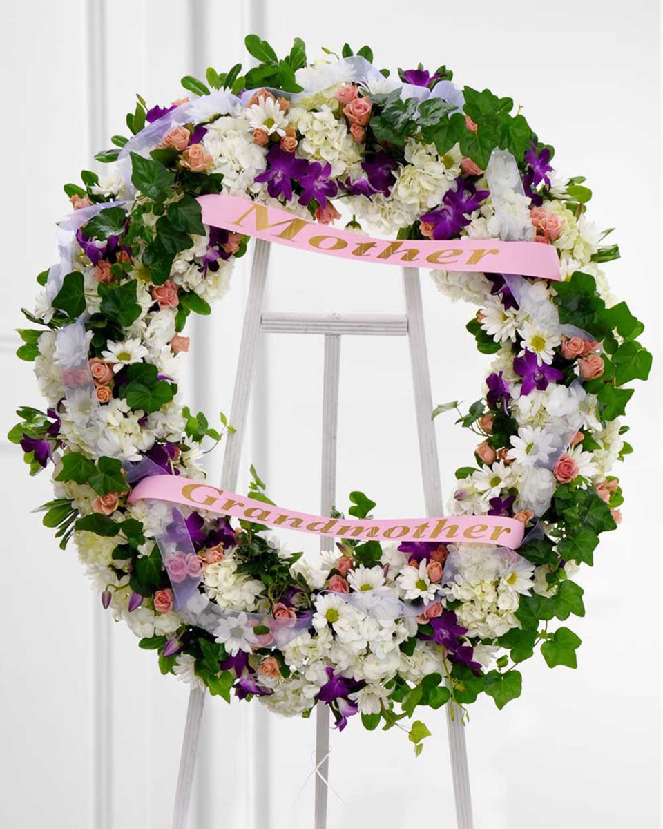 Gentle Woman Standard (18 Inch) With this delicate wreath, remember the wonderful woman who graced your life. Honor her memory by displaying this spray featuring shades of white, purple, and pink.
DELIVERY: Every order is hand-delivered direct to the recipient. These items will be delivered by us locally, or a qualified retail local florist.