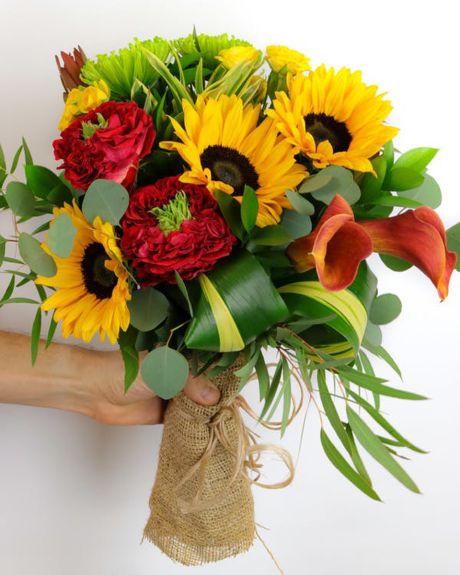 Garden Sun-Featuring a stunning combination of unique flowers, lush greens, and unique textures, this hand-tied bouquet is delivered in a water-retaining floral swaddle, wrapped in burlap, and ready to drop in a vase!-Hand Bouquet