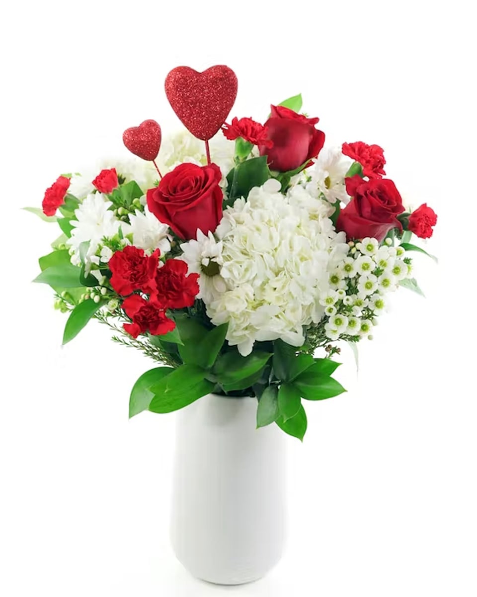 Hearts on Fire Standard Red roses and carnations are exquisitely arranged with white hydrangeas and chrysanthemums in a keepsake white ceramic vase. It's lovely.
DELIVERY: Every order is hand-delivered direct to the recipient. This item is only deliverable to local areas serviced by Allen’s Flower Market Stores.