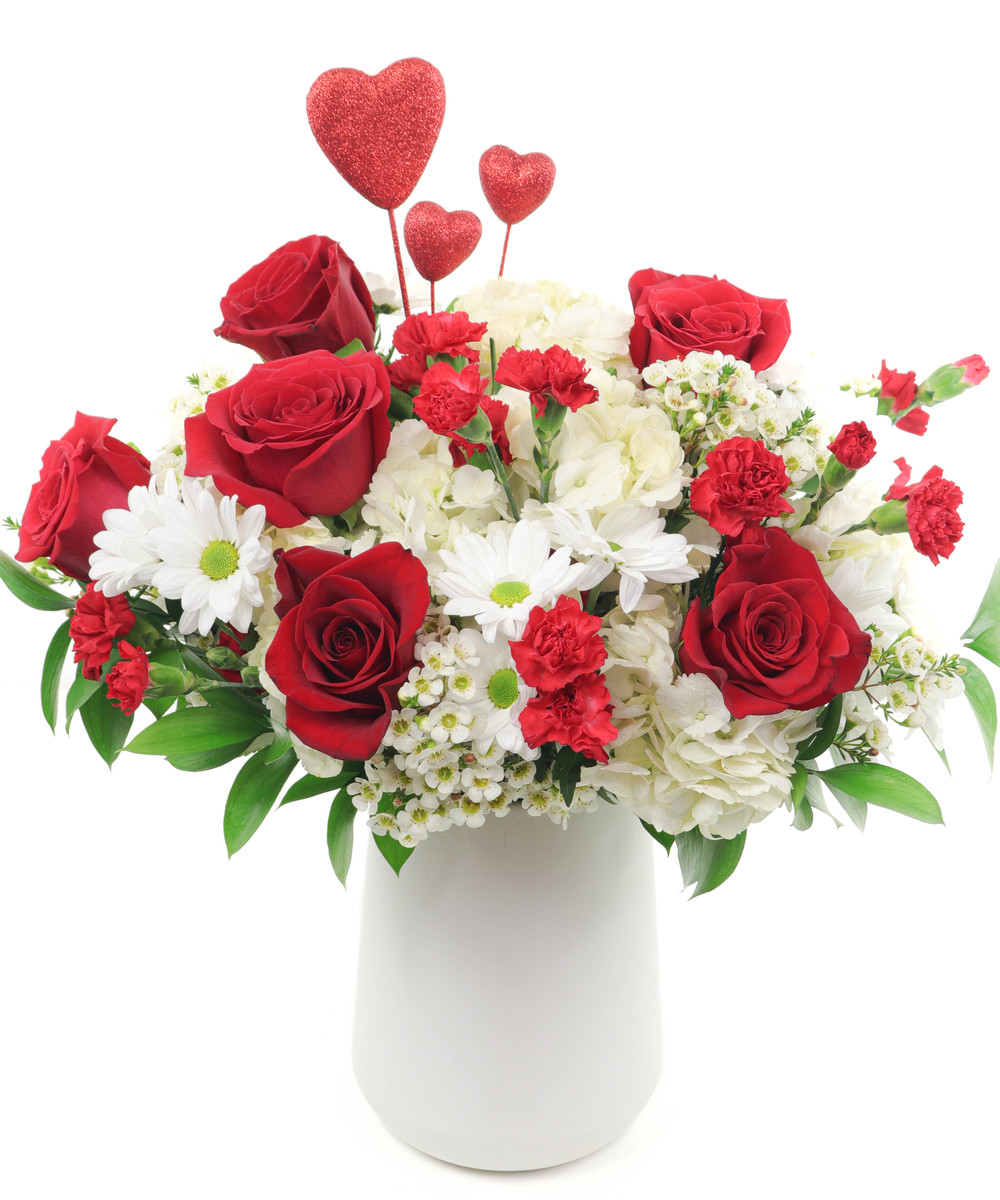 Hearts on Fire Premium Red roses and carnations are exquisitely arranged with white hydrangeas and chrysanthemums in a keepsake white ceramic vase. It's lovely.
DELIVERY: Every order is hand-delivered direct to the recipient. This item is only deliverable to local areas serviced by Allen’s Flower Market Stores.