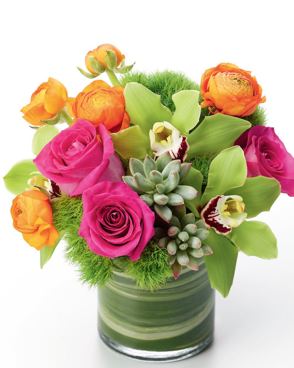 Misty In Long Beach Standard (In a 5 x 5 In Cylinder) Misty in Long Beach
Stunning hot pink roses are arranged with exotic green cymbidium blooms and mixed with orange mini roses and long lasting succulent cuts.  Arranged in a leaf lined glass cylinder, this floral arrangement makes a perfect gift for any occasion.
DELIVERY: Every order is hand-delivered direct to the recipient. These items will be delivered by us locally, or a qualified retail local florist.