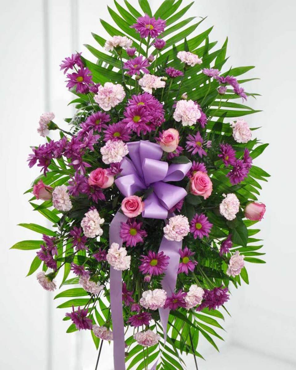 Royal Serenity Standard This sympathy spray will honor your loved one in the most majestic way. Accented by a lavender ribbon, the pink roses and purple daisies provide a flawless tribute.
DELIVERY: Every order is hand-delivered direct to the recipient. These items will be delivered by us locally, or a qualified retail local florist.