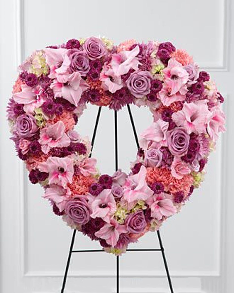 Hearts and Roses Deluxe (24 Inch) Purple Roses, Pink Gladiolus, Pink Carnations, Red and Lavender Pom Pons, and Hydrangea are arranged in an Open Heart Wreath.
DELIVERY: Every order is hand-delivered direct to the recipient. These items will be delivered by us locally, or a qualified retail local florist.