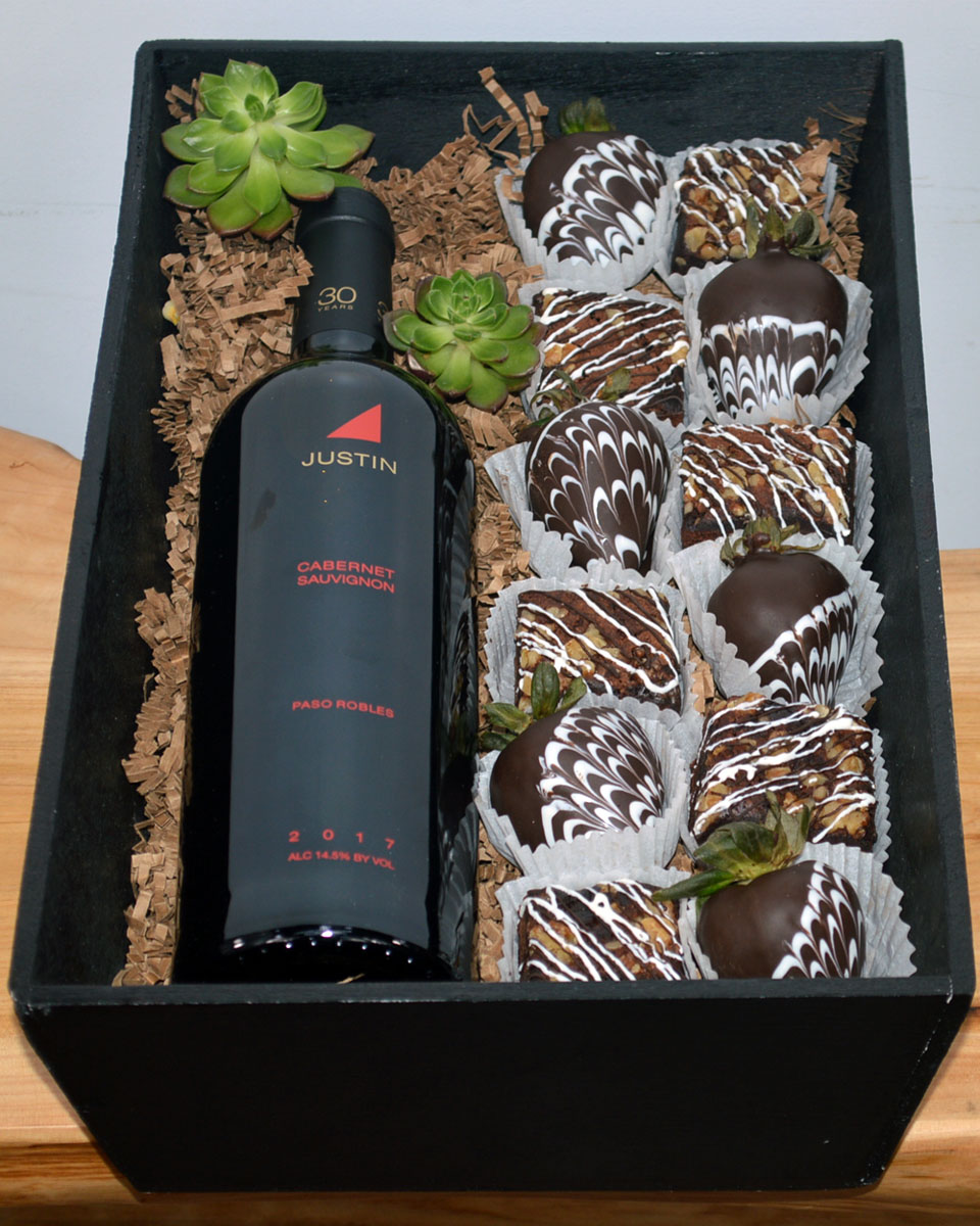 Wine, Brownies, & Strawberries  Justin Cabernet Sauvignon Wine, Brownies, & Strawberries- Fresh, Mouth watering chocolate brownies and irrisistable chocolate covered strawberries are paired with Wine or Champagne of your choice and crafted inside a gift wooden box. The brownies and chocolate covered strawberries are made daily by Babbette Bakery, one of Long Beach's finest and oldest bakeries.
Please give at least a 24 hour notice when ordering these products. This helps insure the freshness and quality. The brownies contain nuts.
DELIVERY: Every order is hand-delivered direct to the recipient. This item is only deliverable to local areas serviced by the Allen’s Flower Market chain and its affiliates.
